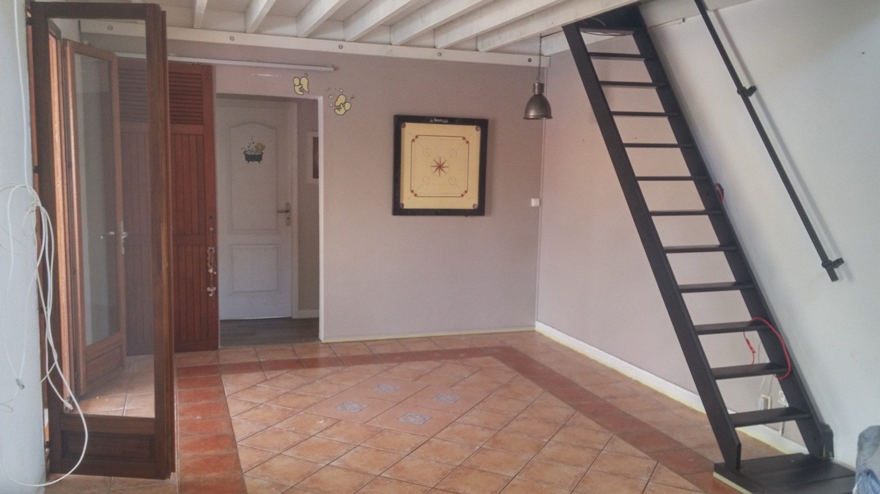 Séjour avec un ancien carrelage en terre cuite daté, avant rénovation