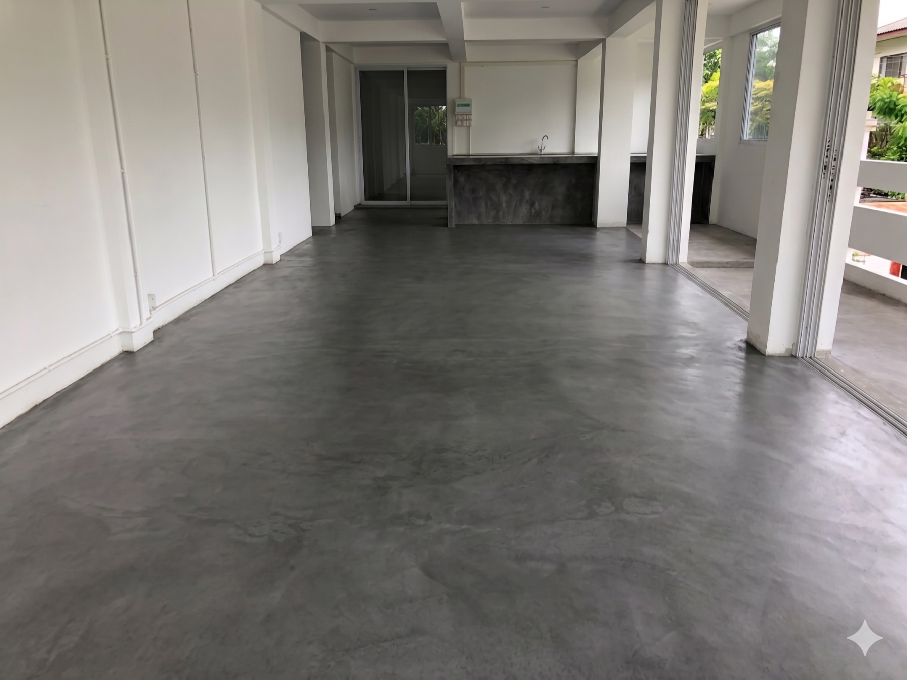 La même varangue après application du béton minéral gris, surface continue sans joint