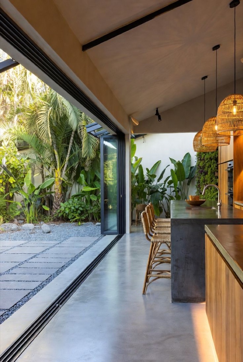 Cuisine ouverte sur un jardin tropical, sol et plan de travail en béton minéral