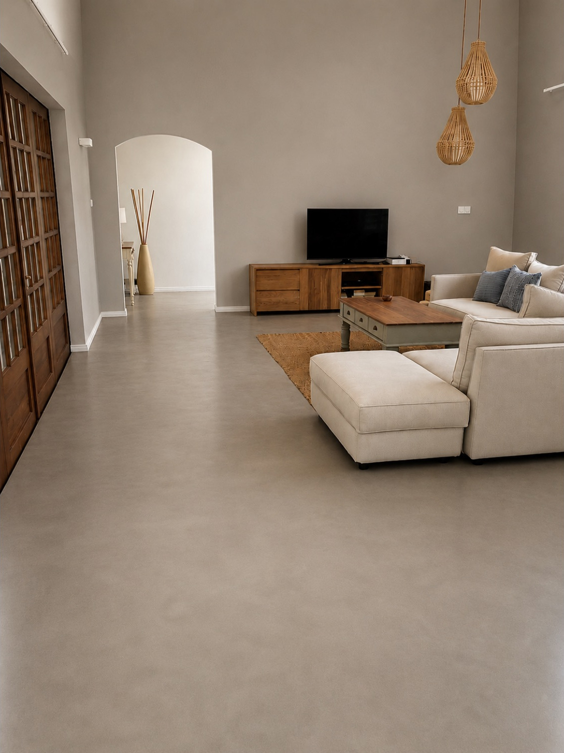 Séjour au sol en béton minéral beige clair avec suspensions en rotin